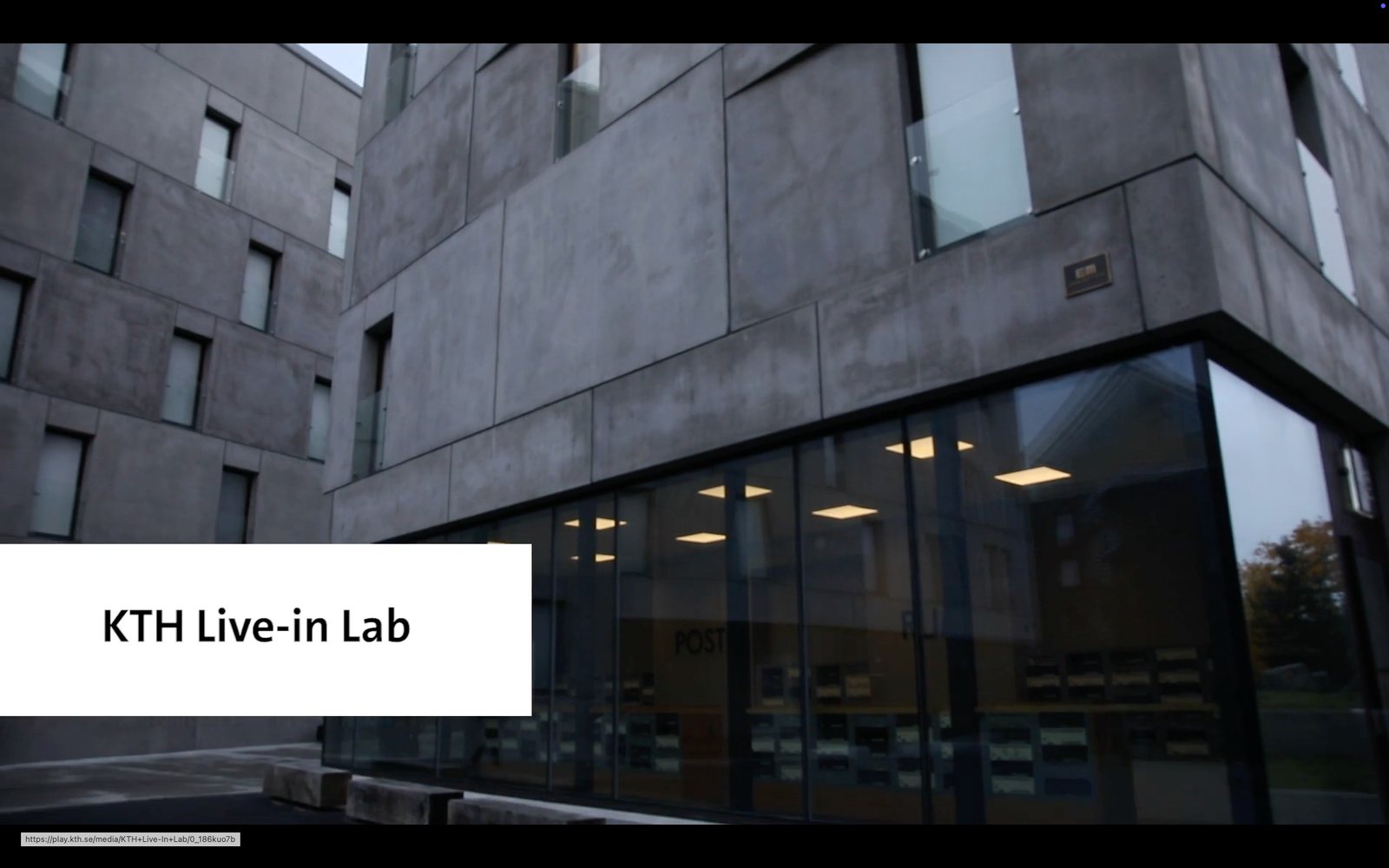 Low-angle view of the KTH Live-in Lab concrete building with a ground-floor glass storefront