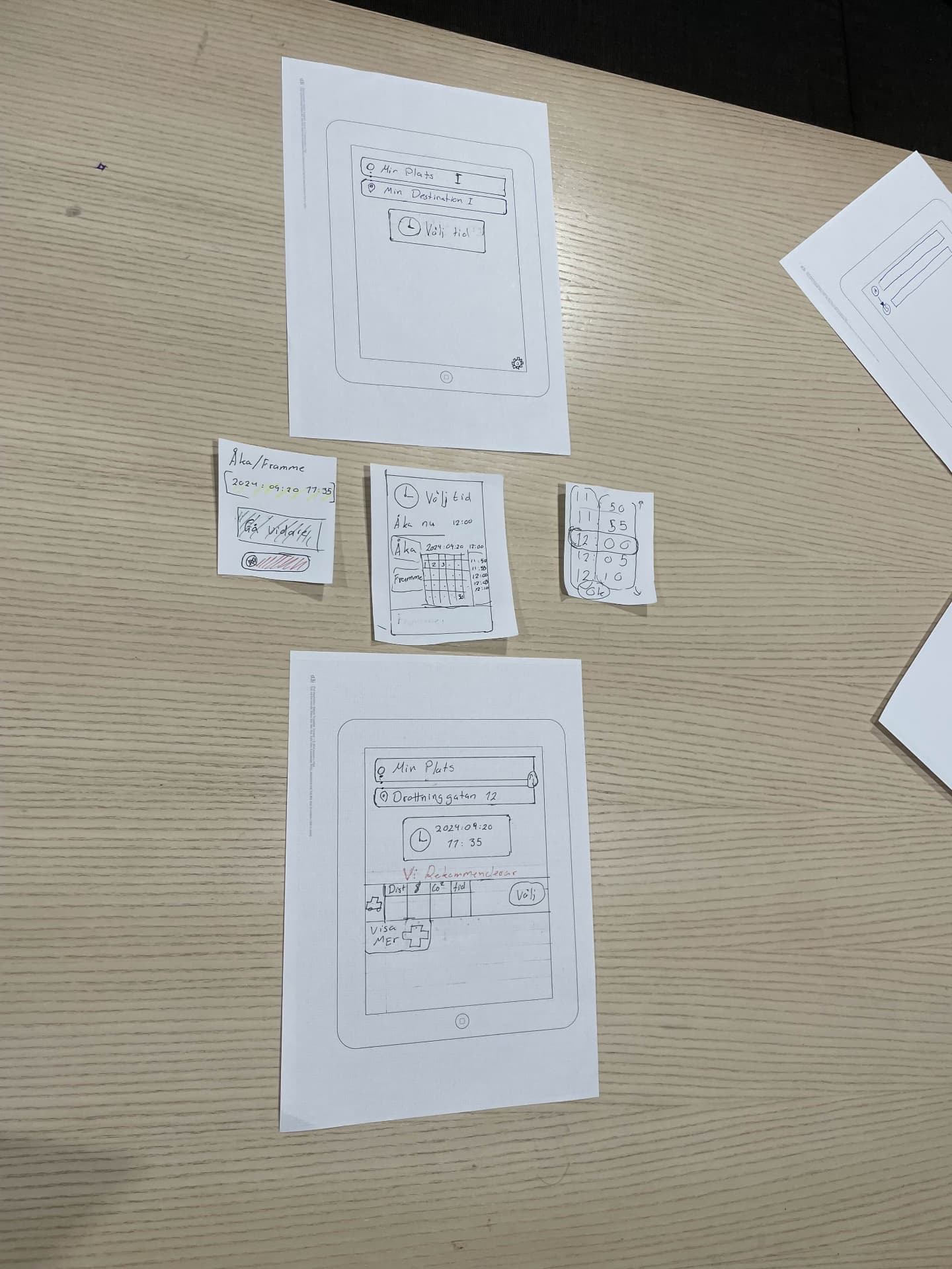 Paper prototypes of the travel app laid out on a table