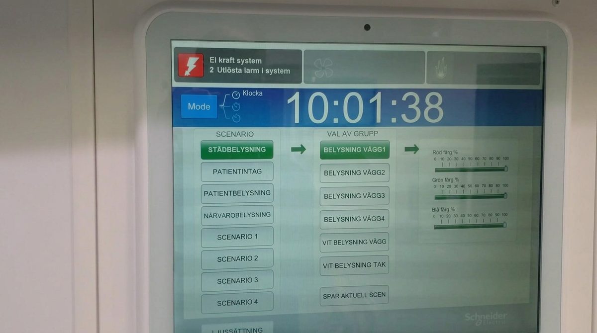 Schneider Electric touch-panel interface showing an electrical-alarm status bar, a digital clock, and columns for lighting scenarios, light-group selection and RGB color sliders