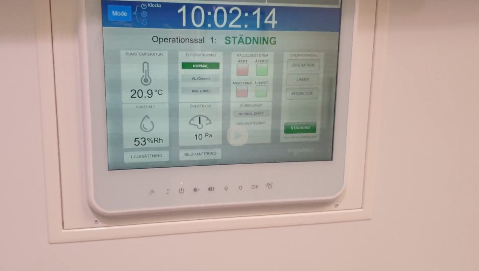 Wall-mounted touch panel showing the operating-theatre overview: cleaning mode active, 20.9°C, 53% relative humidity, 10 Pa overpressure, and power-supply and call-system status