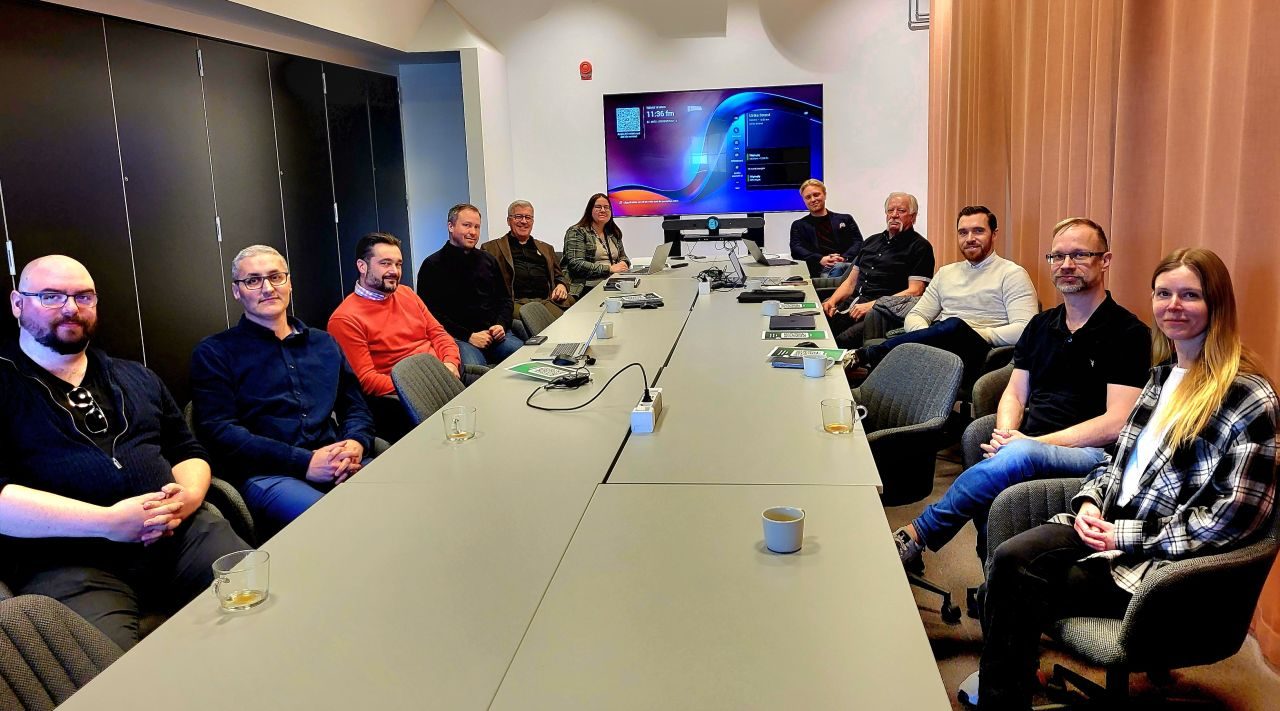 A dozen participants seated around a long table during a Talking Systems project workshop